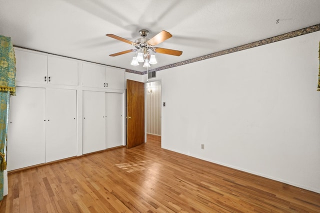 unfurnished bedroom featuring ceiling fan, a closet, and light wood-type flooring