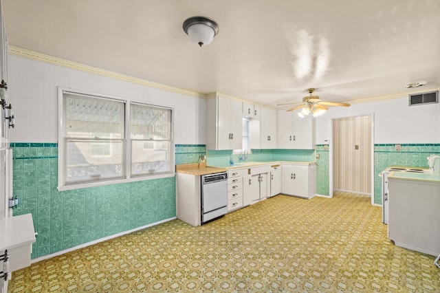 kitchen with sink, white cabinets, dishwashing machine, ceiling fan, and crown molding