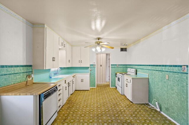 kitchen with white appliances, sink, tile walls, and white cabinets