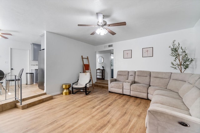 living room with light hardwood / wood-style flooring and ceiling fan