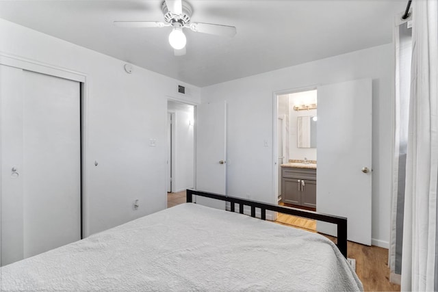 bedroom featuring ceiling fan, connected bathroom, a closet, and light hardwood / wood-style flooring