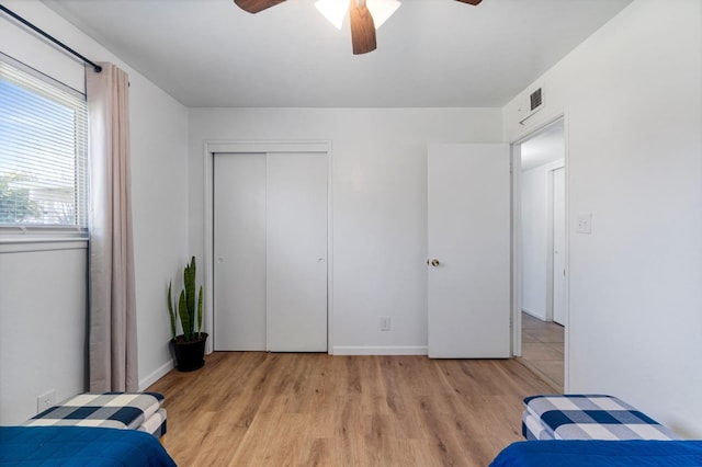 bedroom featuring ceiling fan, a closet, and light hardwood / wood-style flooring