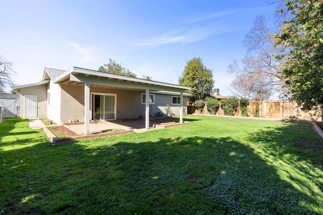 back of house with a yard and a patio area