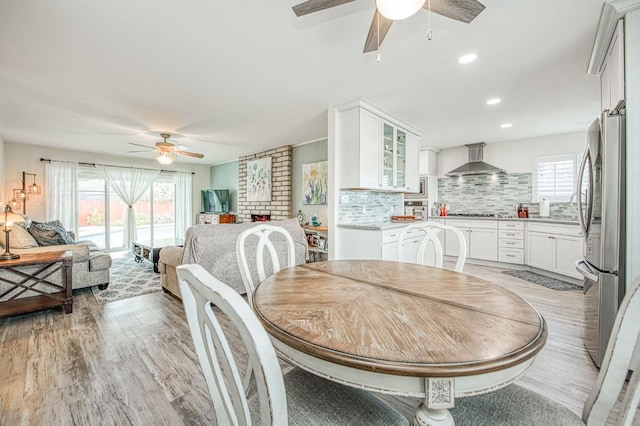 dining area with ceiling fan, a healthy amount of sunlight, and light wood-type flooring