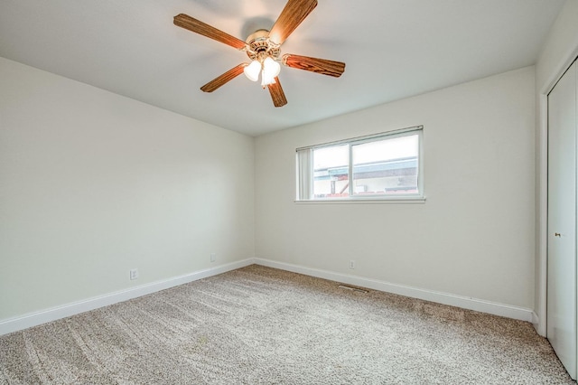 carpeted spare room featuring ceiling fan