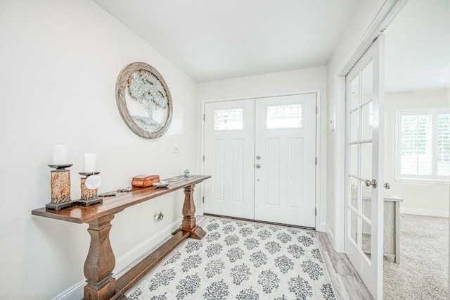 entryway with light hardwood / wood-style floors and french doors