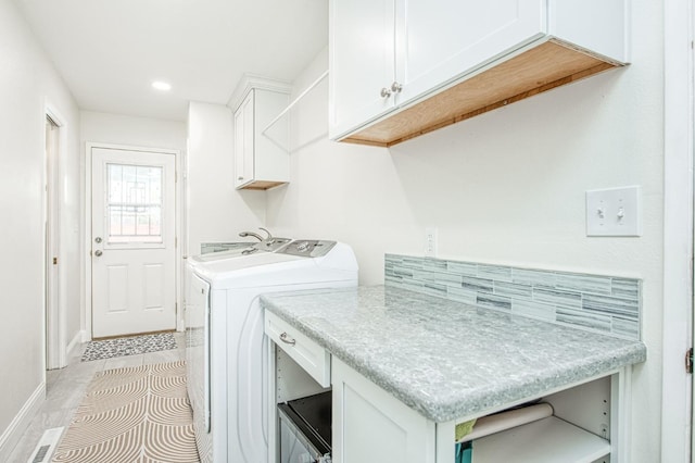 laundry room with cabinets, washing machine and dryer, and light tile patterned floors