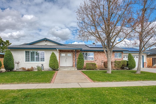 ranch-style house with a garage, a front yard, and solar panels