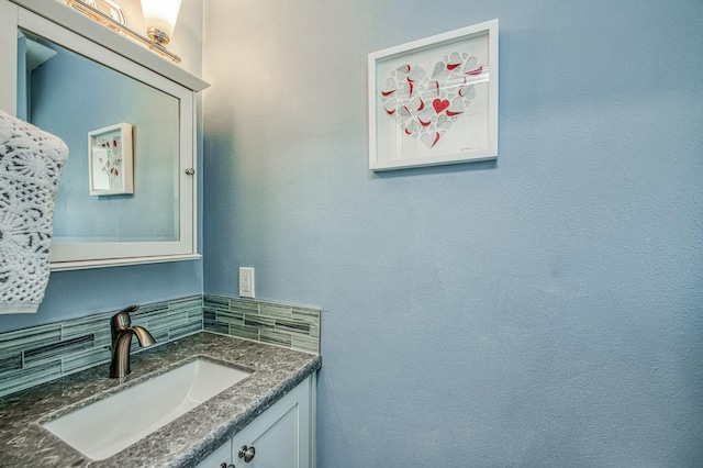 bathroom with tasteful backsplash and vanity