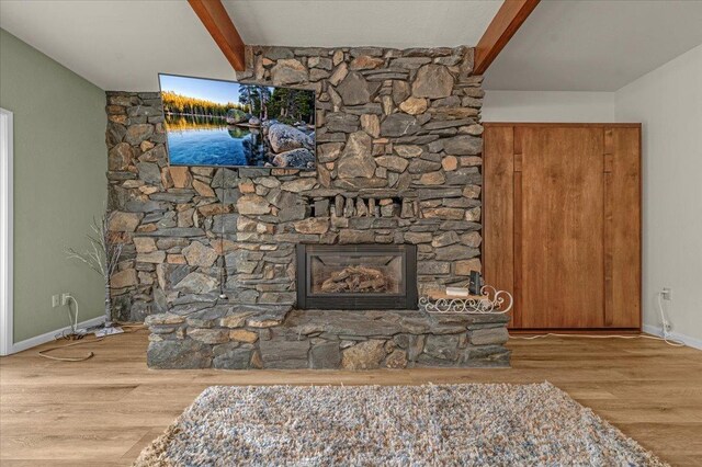 room details with beam ceiling, hardwood / wood-style flooring, and a fireplace