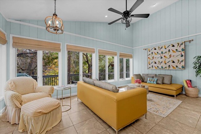 interior space with ceiling fan with notable chandelier and high vaulted ceiling