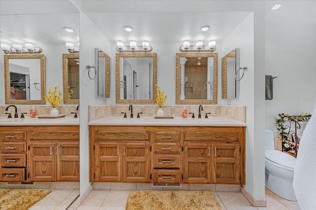 bathroom with tile patterned flooring, toilet, vanity, and decorative backsplash