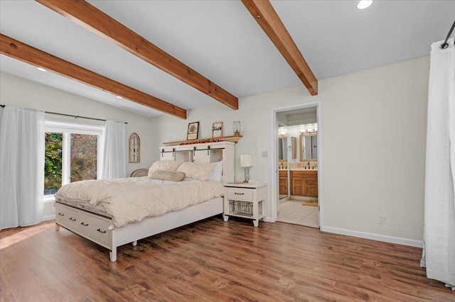 bedroom featuring sink, lofted ceiling with beams, dark hardwood / wood-style floors, and ensuite bathroom