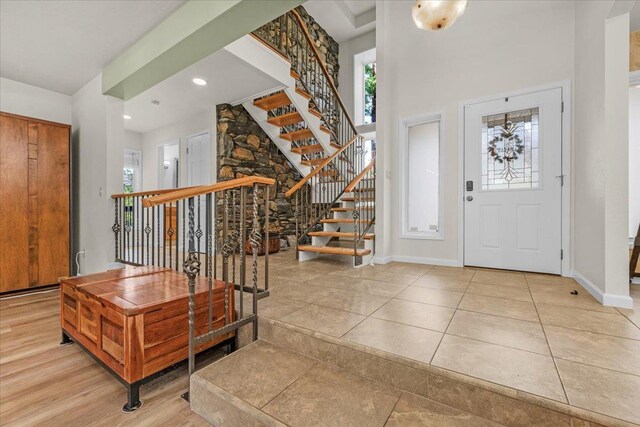 foyer entrance featuring light tile patterned flooring and a towering ceiling