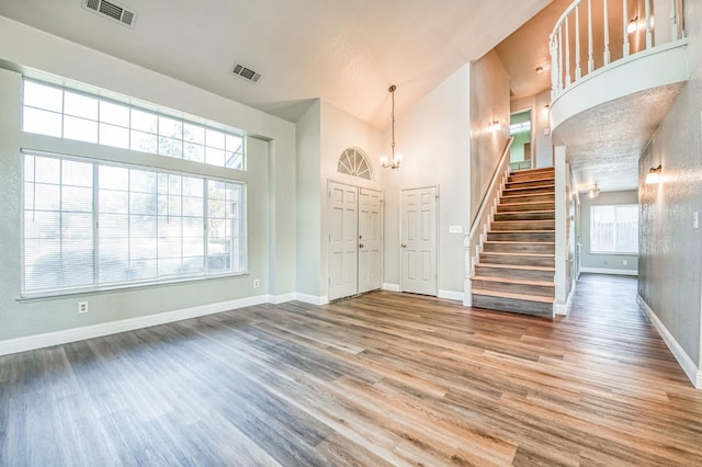 entryway with stairs, wood finished floors, visible vents, and baseboards