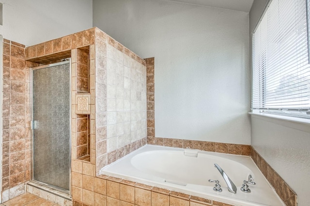 full bathroom with a shower stall and a bath