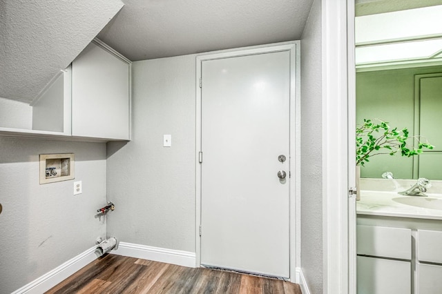 laundry room with baseboards, dark wood-style flooring, a sink, washer hookup, and a textured ceiling