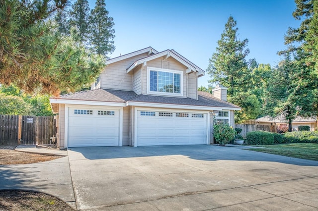 view of front of property with concrete driveway, fence, a chimney, and a shingled roof