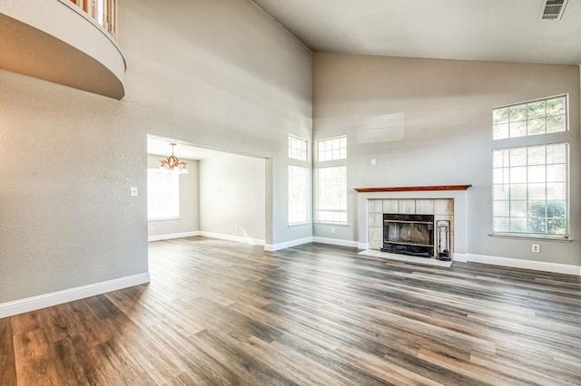 unfurnished living room with wood finished floors, plenty of natural light, a fireplace, and visible vents