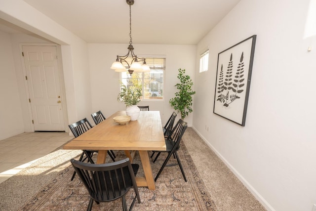 dining room with light tile patterned floors and an inviting chandelier