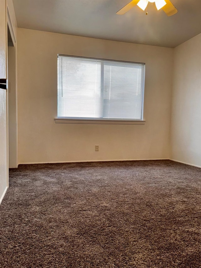 carpeted spare room with ceiling fan