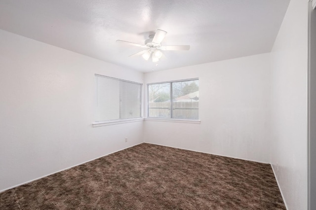 empty room featuring ceiling fan and carpet