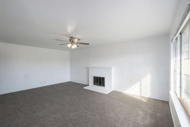 unfurnished living room featuring ceiling fan, a fireplace, and carpet