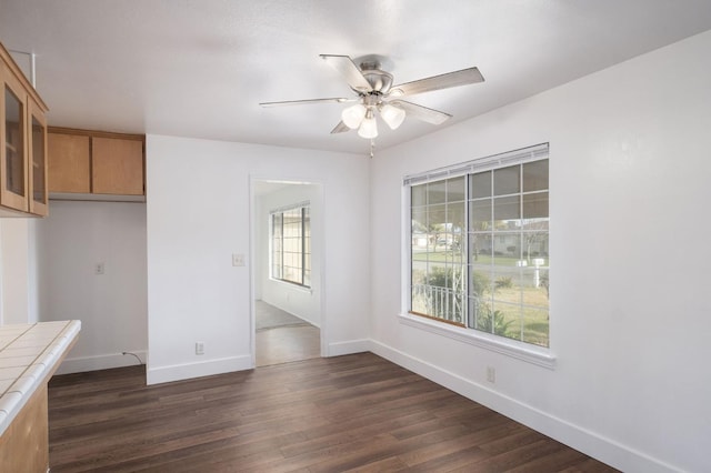 unfurnished dining area featuring dark hardwood / wood-style flooring and ceiling fan