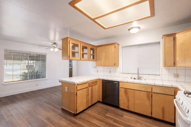 kitchen with black dishwasher, sink, decorative backsplash, tile counters, and white gas stove