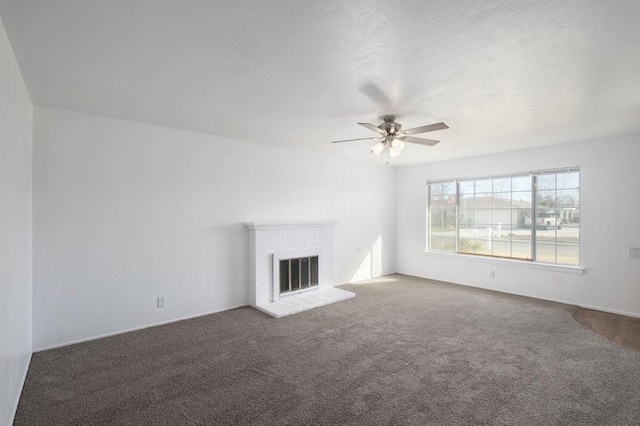 unfurnished living room featuring ceiling fan, a fireplace, carpet, and a textured ceiling