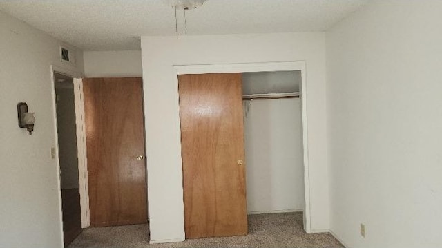 unfurnished bedroom with carpet floors and a closet