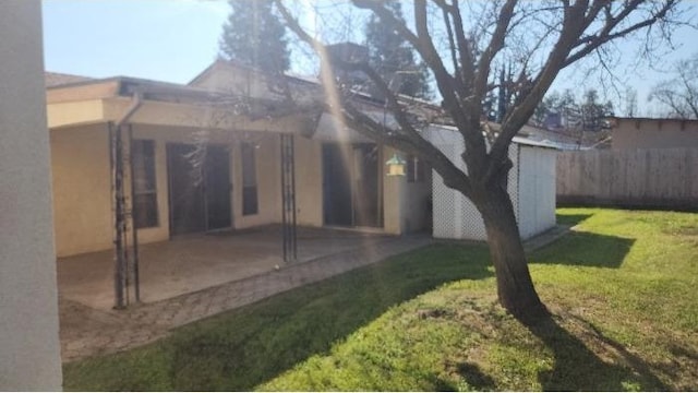 back of property featuring a patio area and a lawn