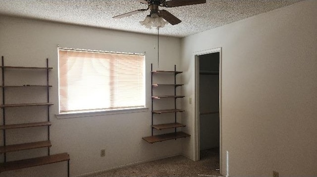 unfurnished bedroom with ceiling fan, a textured ceiling, and a closet