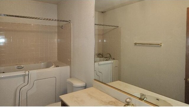 bathroom featuring tiled shower / bath and vanity