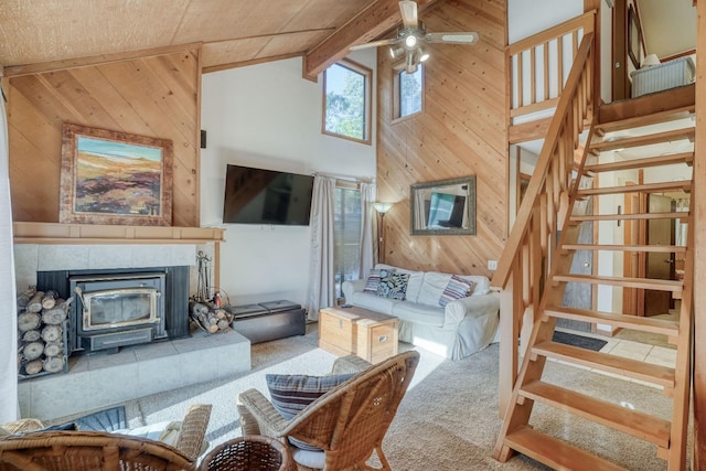 living room featuring ceiling fan, wooden walls, high vaulted ceiling, carpet flooring, and beamed ceiling