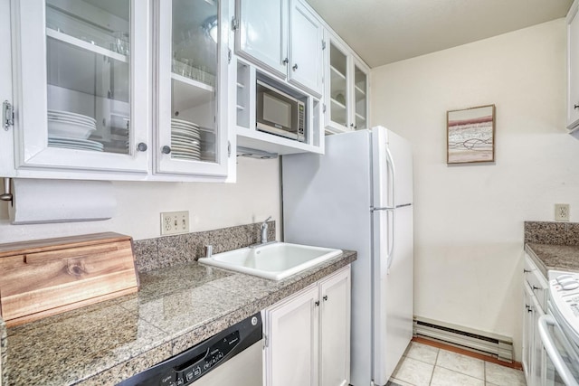 kitchen featuring stainless steel appliances, white cabinetry, sink, and light tile patterned flooring