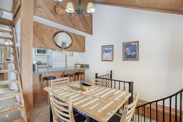 carpeted dining room with vaulted ceiling and a notable chandelier