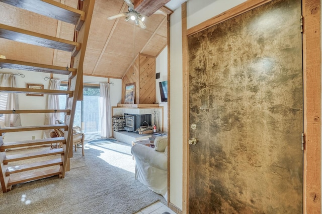 interior space featuring a tiled fireplace, carpet floors, high vaulted ceiling, and ceiling fan