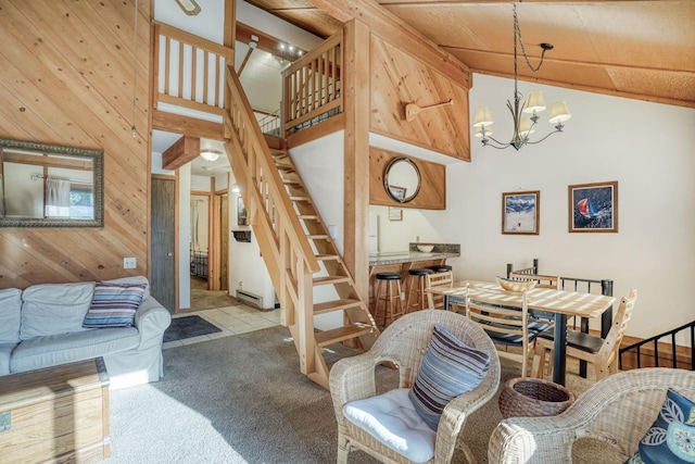 living room with high vaulted ceiling, a chandelier, light colored carpet, and wooden walls