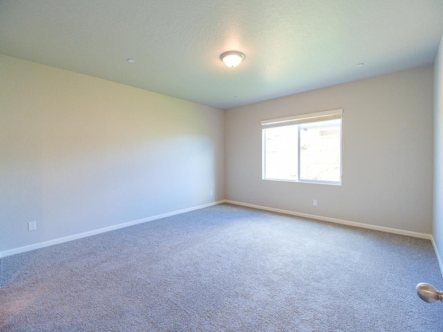 carpeted empty room with a textured ceiling