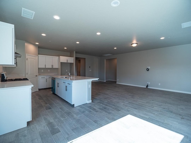 kitchen featuring dark wood-type flooring, dishwasher, range, a kitchen island with sink, and white cabinetry