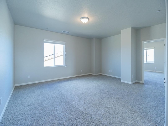 carpeted spare room featuring a textured ceiling