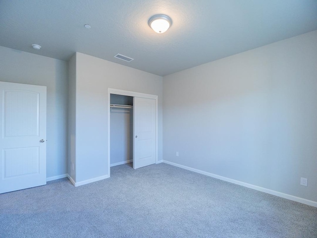 unfurnished bedroom featuring a closet and carpet flooring