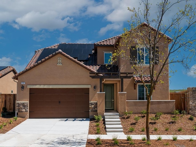 mediterranean / spanish-style home featuring a garage and solar panels