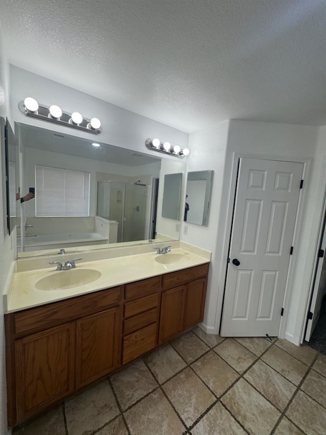 bathroom with independent shower and bath, vanity, and a textured ceiling