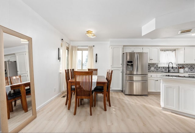 dining space with light wood-style floors and baseboards