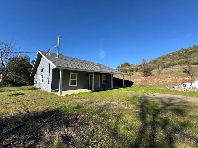 back of property featuring a lawn