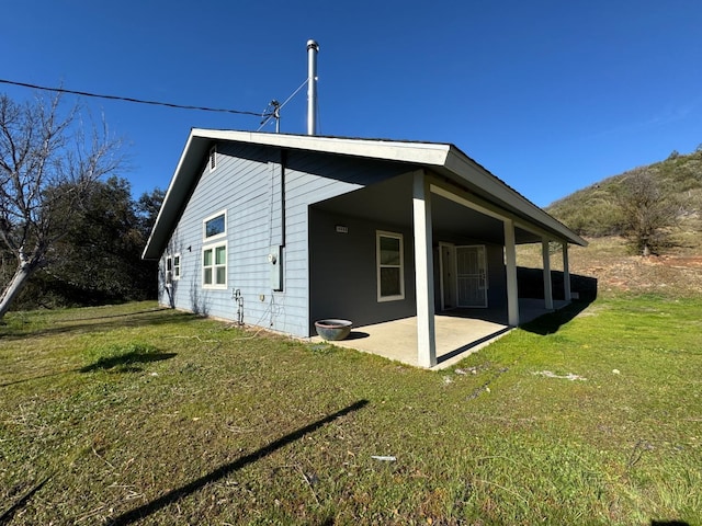 back of house featuring a patio area and a yard