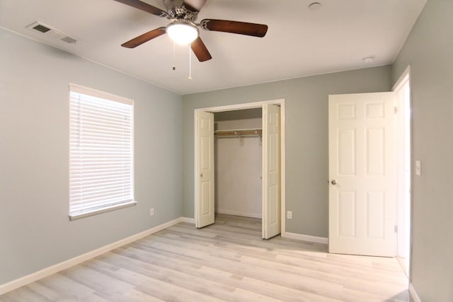unfurnished bedroom with light wood finished floors, baseboards, visible vents, and a closet