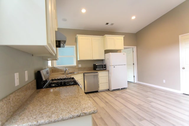 kitchen with light wood-style flooring, appliances with stainless steel finishes, white cabinetry, a sink, and recessed lighting